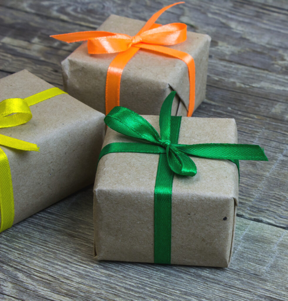 3 brown paper wrapped gifts with colorful ribbons.