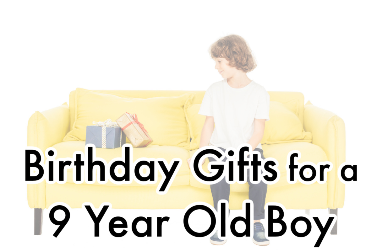 young child sitting on bright yellow sofa looking at several birthday gifts.