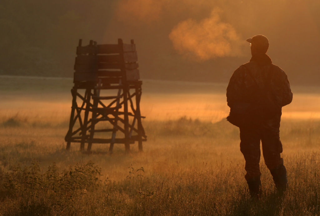 man and hunting blind in misty field.