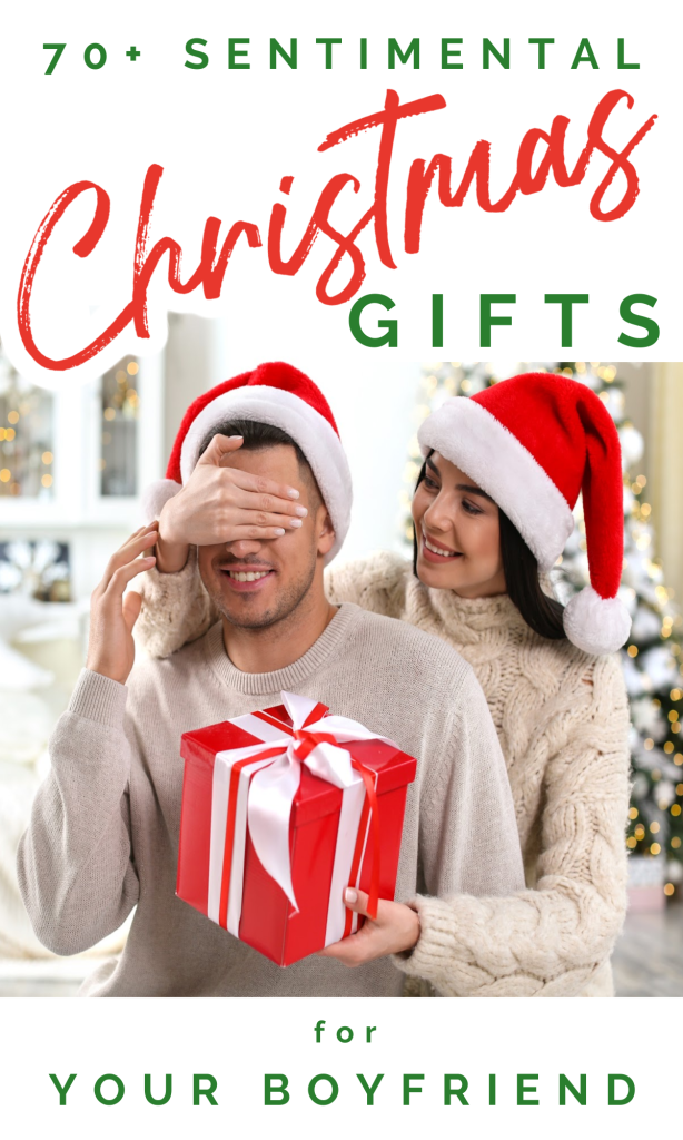 woman covering man in Santa hat's eyes and man holding red gift.