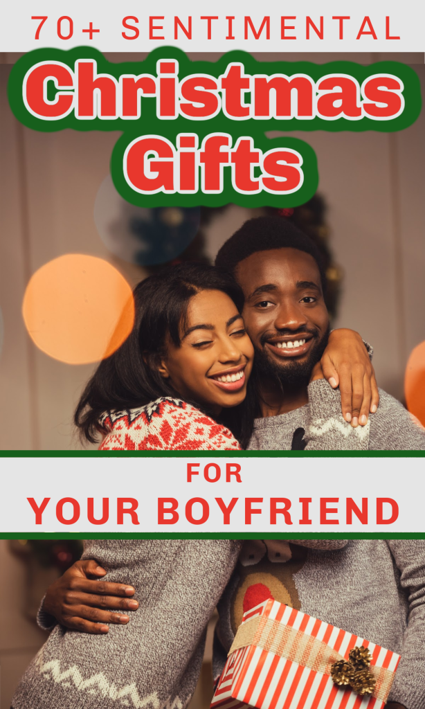 smiling black woman and man holding gift in front of holiday wreath.