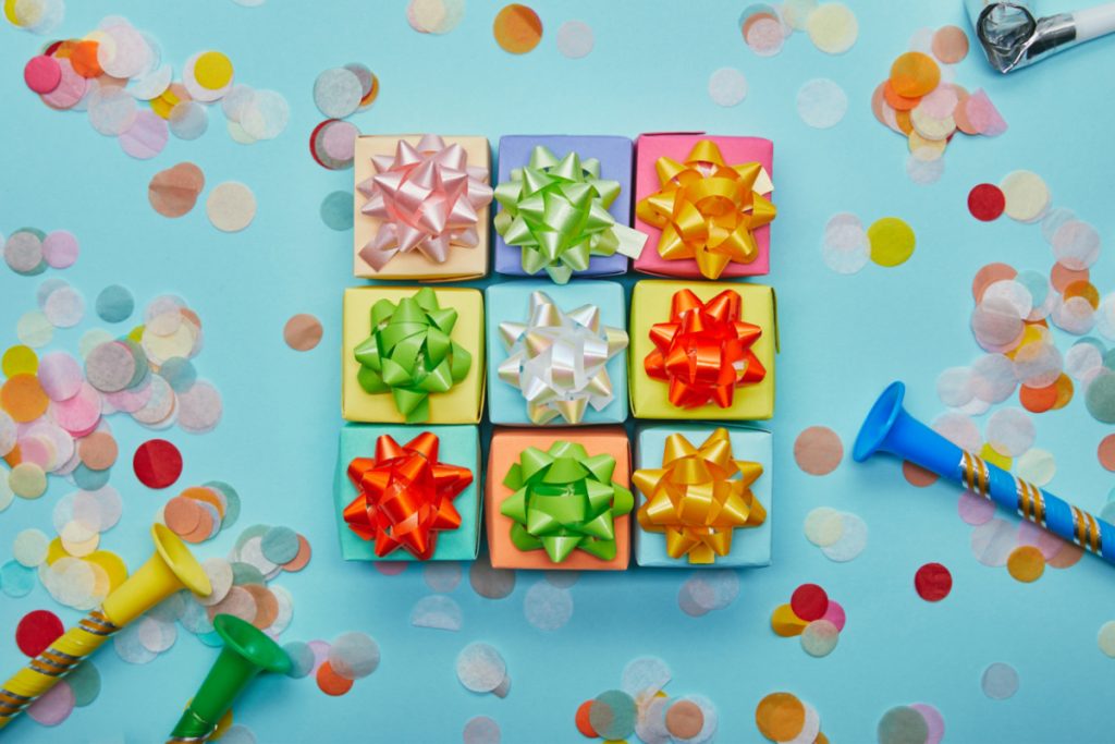 Colorful gift boxes and confetti on a blue background.
